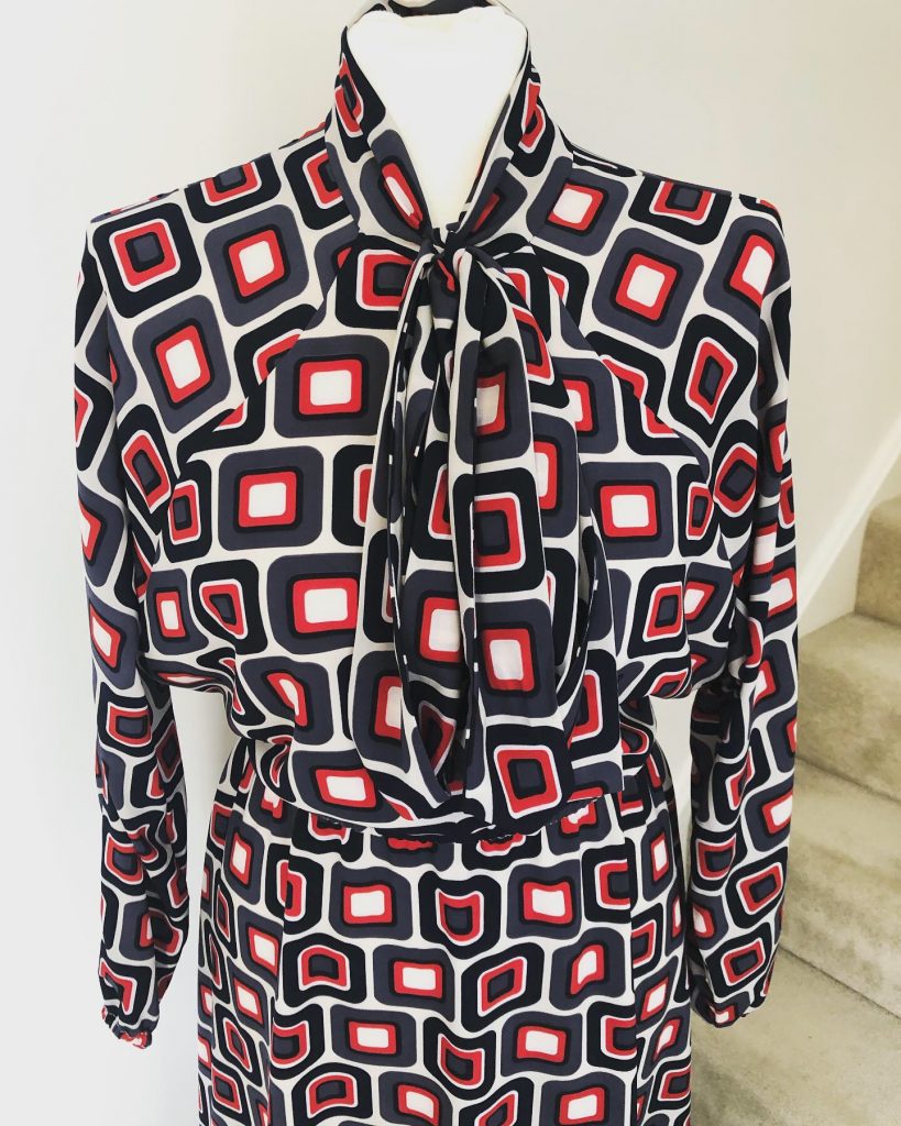 Stella shirt dress on mannequin with close up of neck tie