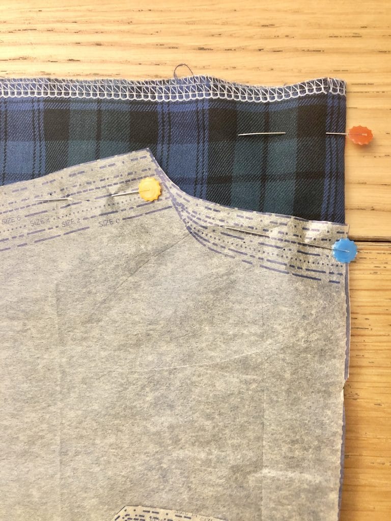 pattern piece laid onto tartan fabric