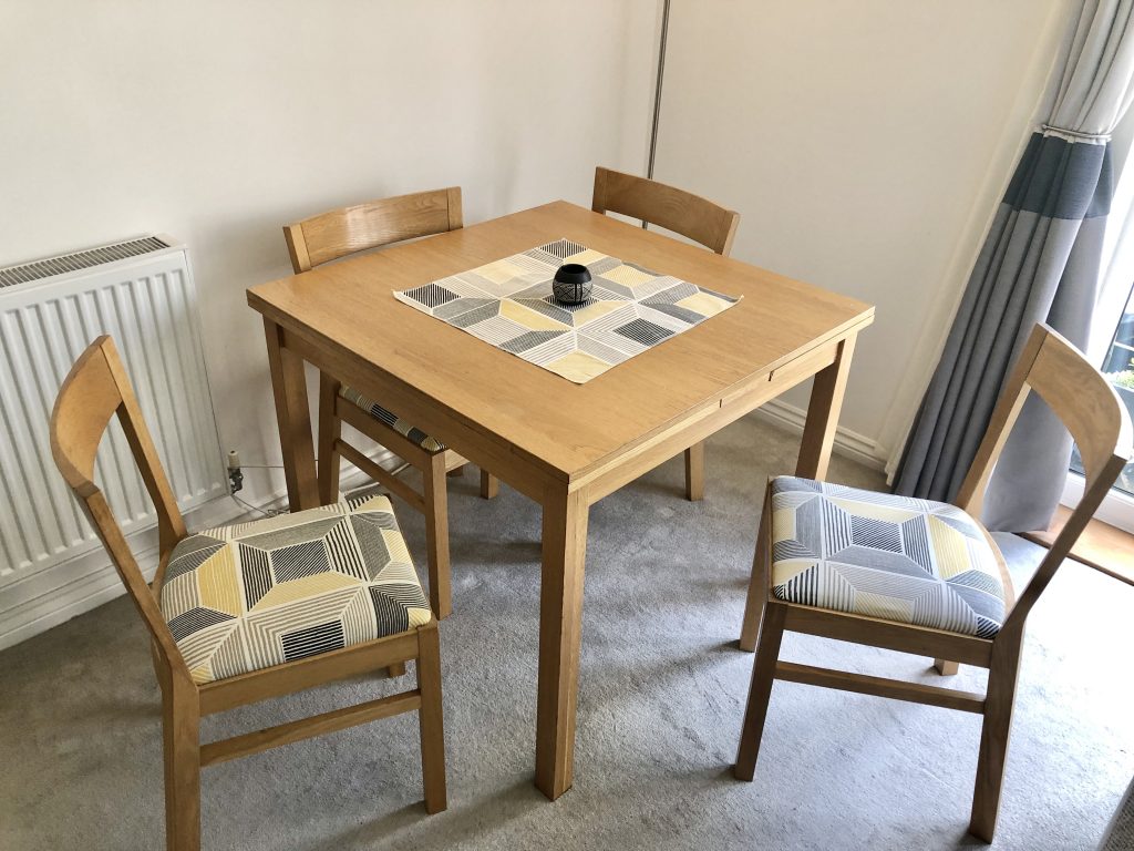 Table and Chairs with ikea geometric grey and yellow print on the seat pad