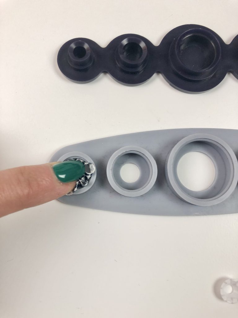 button and fabric pushed into silicone base
