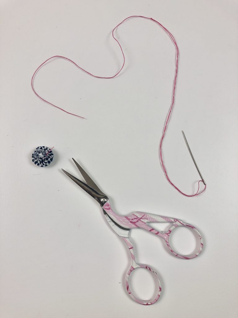 button, thread and scissors