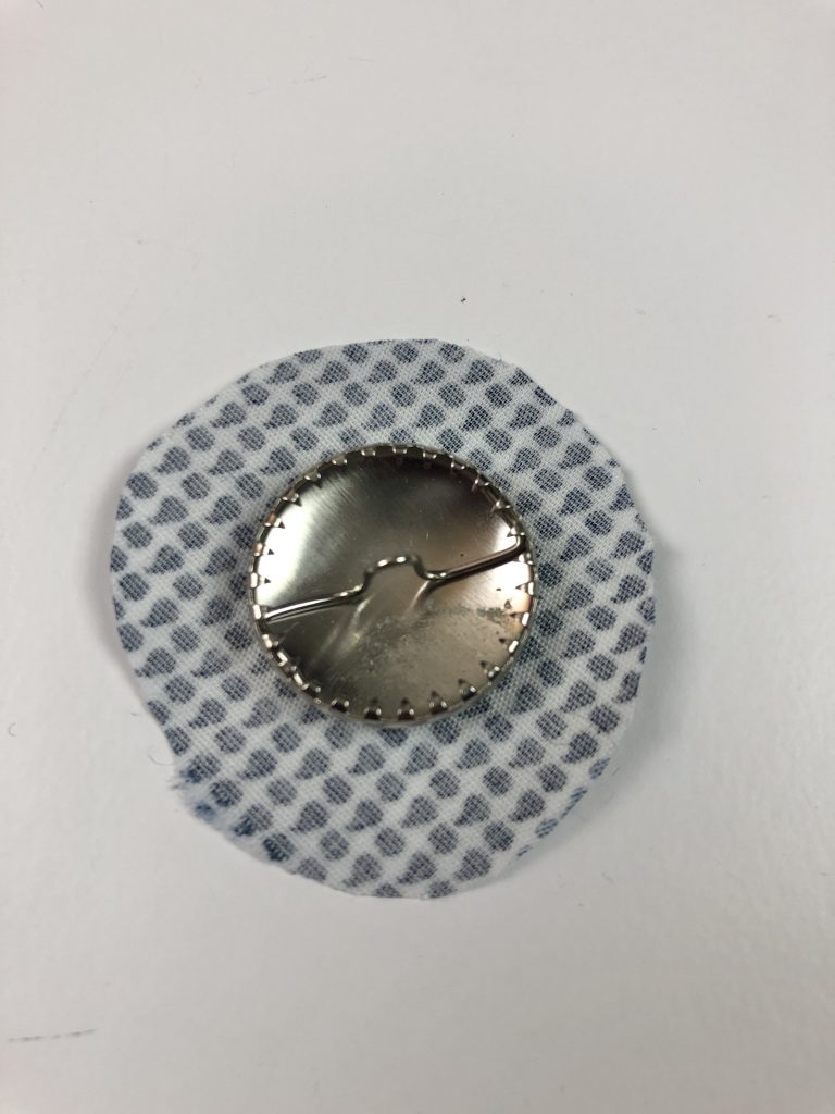 metal button in centre of fabric circle