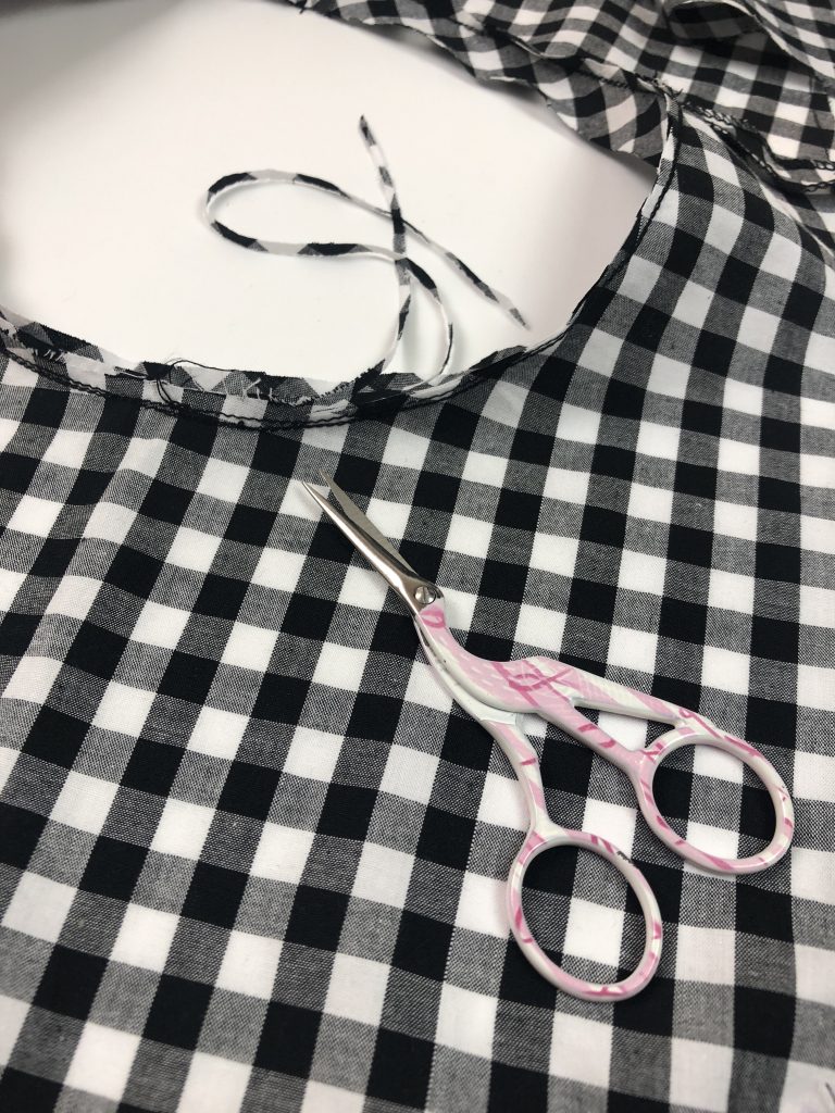 black gingham fabric with pink scissors