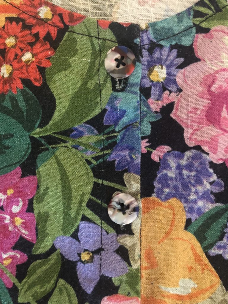 Close up of multicoloured buttons on front of floral blouse