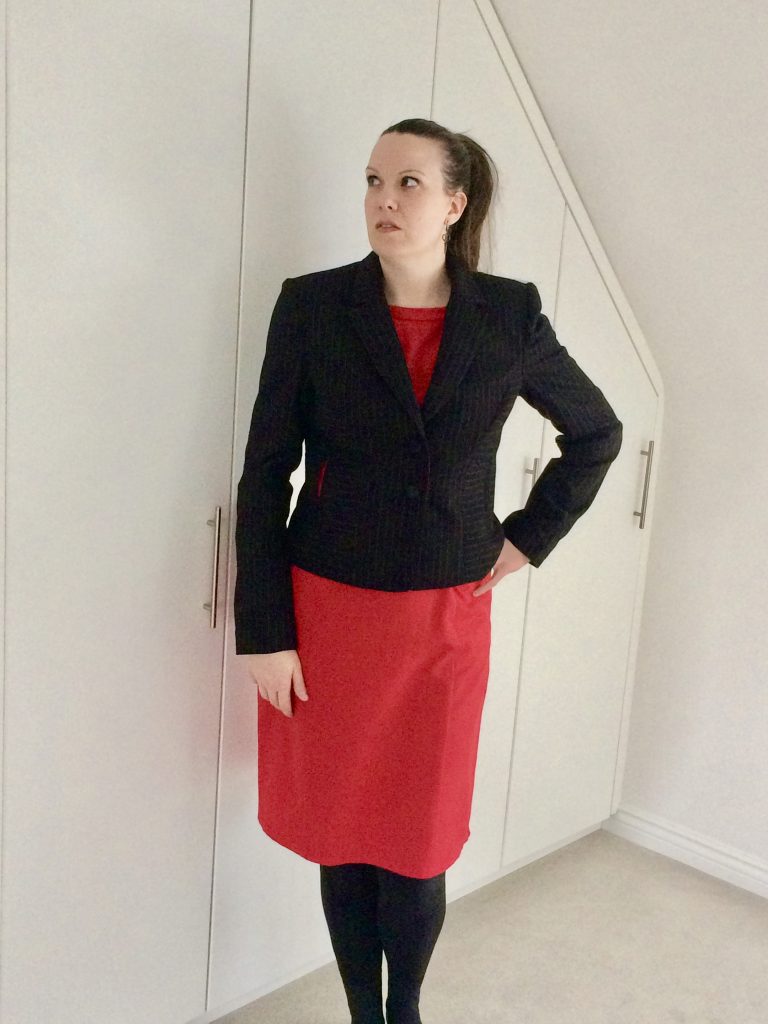 Julia wearing the jacket with a red dress and black leggings