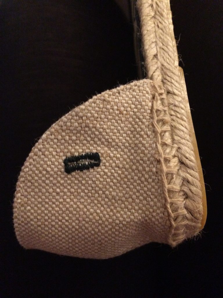 close up of buttonhole in heel section which is now sewn to the espadrille sole